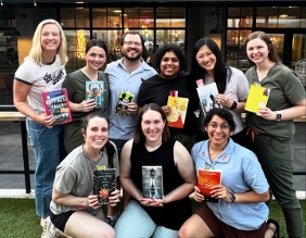 outdoor group picture of residents holding up books with bookmarks inserted